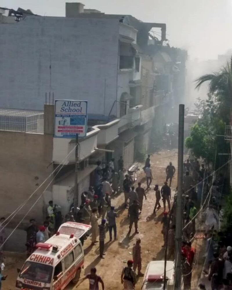 An ambulance arrives at the crash site of PIA flight PK 8303.  EPA