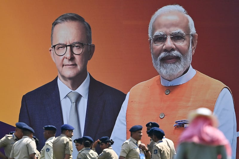 Police stand next to a poster of Anthony Albanese and Narendra Modi in Ahmedabad. AFP