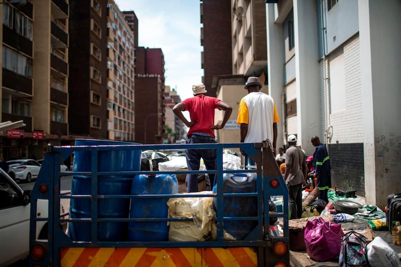 oMalayitsha (transporters) load goods onto a trailer in central Johannesburg to be taken across the border to clients in Zimbabwe on February 20, 2019.  Items are loaded in Johannesburg onto trailers attached to minibuses which make the 550 kilometres (340 miles) journey north to the border of Zimbabwe, where economic situation has dramatically deteriorated, pushing inflation above 50 percent, and shortages of household essentials have become widespread. / AFP / GULSHAN KHAN 
