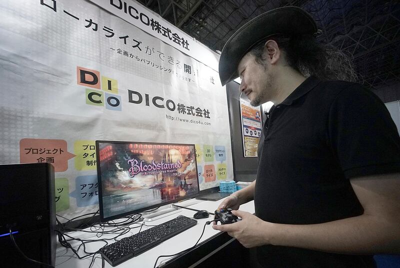 Game creator Koji Igarashi plays a new game called "Bloodstained: Ritual of the Night" while speaking during an interview at the Tokyo Game Show. Eugene Hoshiko / AP Photo