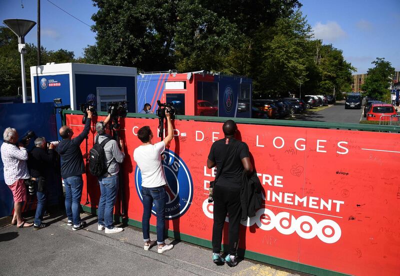 Journalists film and take pictures while Paris Saint-Germain players leave the team's "Camp des Loges" training grounds. AFP