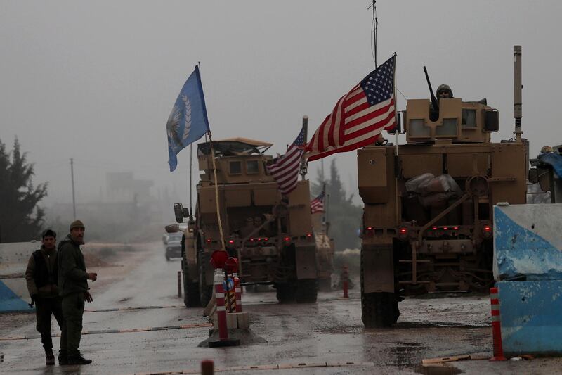 A line of US military vehicles drive through a checkpoint of the Internal Security Forces in Manbij as they head to their base on the outskirts of the northern Syrian city on December 30, 2018.  President Donald Trump announced last week that US troops would depart from Syria, leaving Manbij residents dreading a long-threatened attack by Turkey.  / AFP / Delil SOULEIMAN
