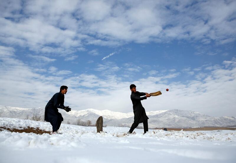 Afghan men play cricket on a field covered in snow on the outskirts of Kabul, Afghanistan. Mohammad Ismail / Reuters