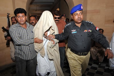 Pakistani police escort Qari Saifullah Akhtar, a militant with links to Osama bin Laden in connection with an October 2007 assassination attempt on Benazir Bhutto, to a court appearance in Karachi on March 15, 2008. Akhtar, who was accused by Bhutto of plotting against her in her posthumously published memoirs, was seized February 25. Akhtar, the one-time head of Harkat Jihad-e-Islami, the main Pakistan support group for Afghanistan's Taliban regime, was arrested in the United Arab Emirates in August 2004 and later extradited to Pakistan.    AFP PHOTO/Asif HASSAN / AFP PHOTO / ASIF HASSAN