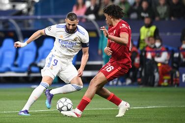 Real Madrid's French striker Karim Benzema (L) fights for the ball with Liverpool's English defender Trent Alexander-Arnold (R) during the UEFA Champions League final football match between Liverpool and Real Madrid at the Stade de France in Saint-Denis, north of Paris, on May 28, 2022.  (Photo by Anne-Christine POUJOULAT  /  AFP)
