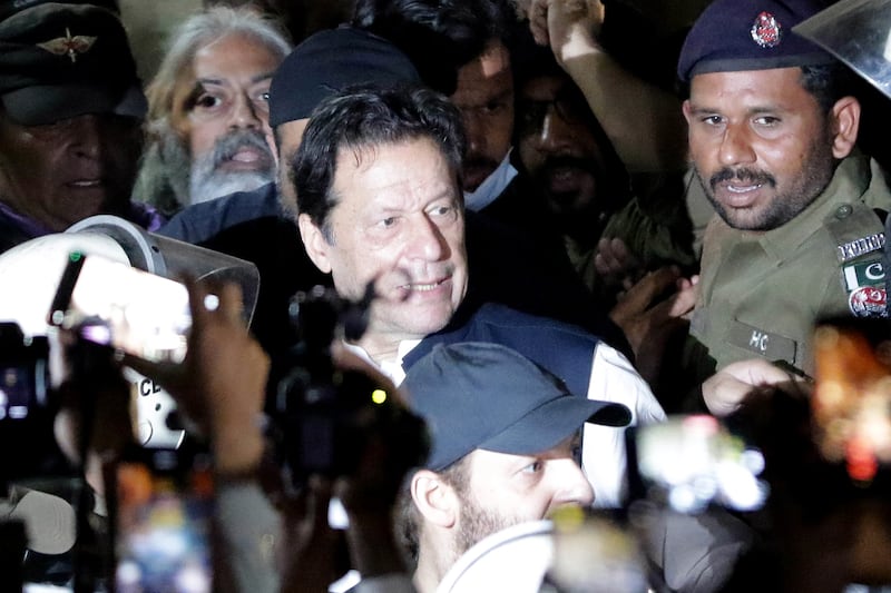 Imran Khan, former prime minister of Pakistan and head of opposition party Pakistan Tehrik-e-Insaf, centre, leaves the High Court in Lahore, where on Friday he was granted protective bail following dozens of arrest warrants. EPA 