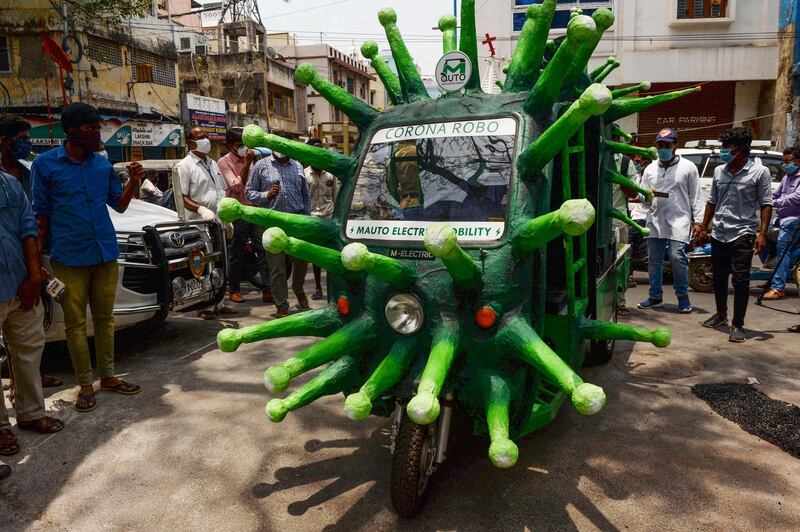 A municipal worker drives a coronavirus-themed auto-rickshaw in a street in Chennai.  AFP