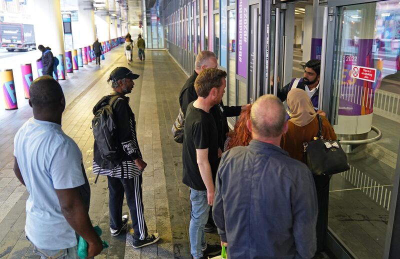 Passengers wait to board a train at Birmingham New Street. PA
