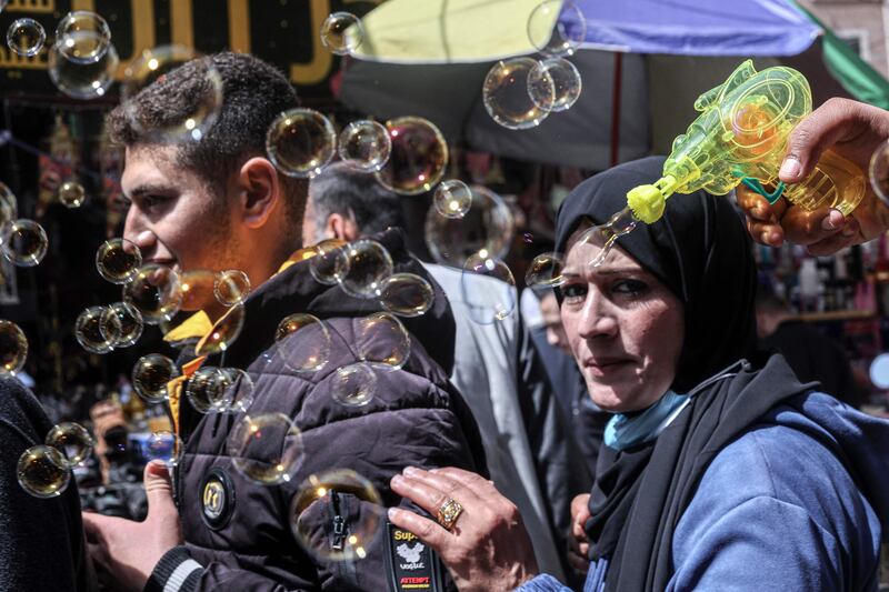 A street vendor plays with a bubble gun in Khan Yunis.  AFP