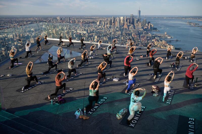 Yoga practitioners attend a class on the Edge Observation Deck, billed as the 'highest outdoor sky deck in the Western Hemisphere' at 1,131 feet (345 meters), and overlooking the Manhattan skyline, in New York.  Pandemic restrictions have been gradually lifted in the US with just over 52 per cent of the US population, or 174 million people, having received at least one dose, according to health officials. AFP
