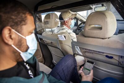 epa08408243 A driver of the Uber company picks up a customer in his vehicle equipped with an acrylic glass protective screen in Lausanne, Switzerland, 07 May 2020, amid the ongoing pandemic of the COVID-19 disease caused by the SARS-CoV-2 coronavirus.  EPA/JEAN-CHRISTOPHE BOTT