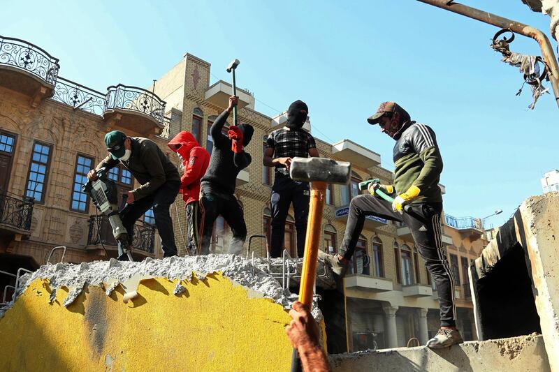 Protesters smash concrete walls that were set by security forces to close Rasheed street on Thursday. AP Photo