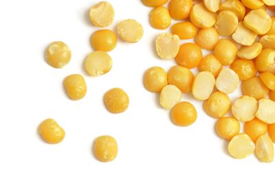 Yellow Split Peas scattered over a white background. Getty Images