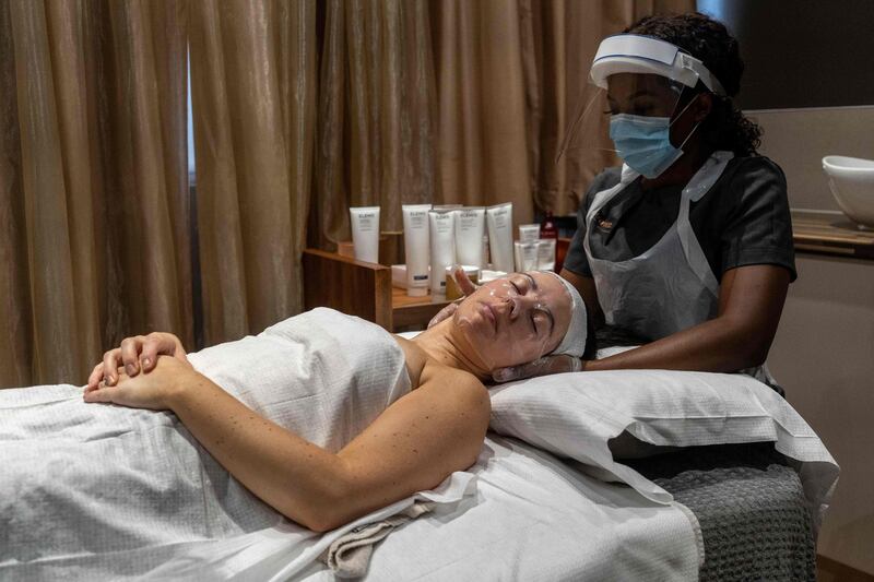 Wearing full PPE (personal protective equipment), Theresa Shangazhike, manager of the Spa Experience Wimbledon, gives her client, Lauren Shine a facial treatment in Wimbledon, south London, as beauty salons, spas and hairdressers relax the regulations to combat the coronavirus, now offering additional services, including front-of-face treatments.  AFP