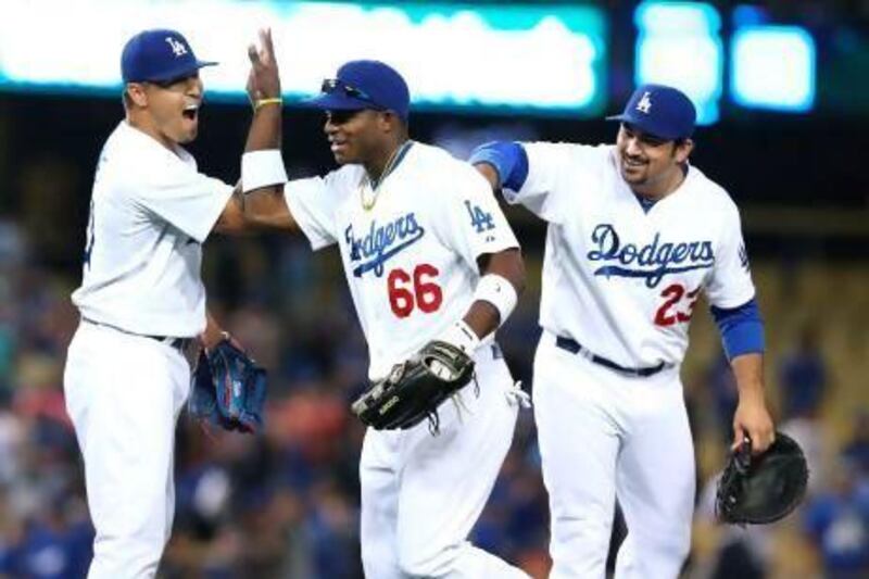 Yasiel Puig, centre, has electrified fans at Dodger Stadium with his bat and his glove.