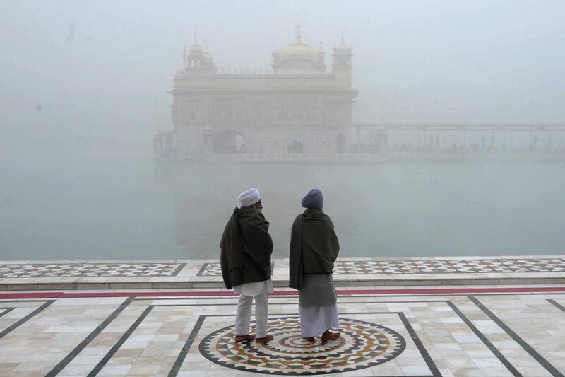 Indian Sikh devotees offer prayers at the Golden Temple on a foggy morning in Amritsar, India. Narinder Nanu / AFP