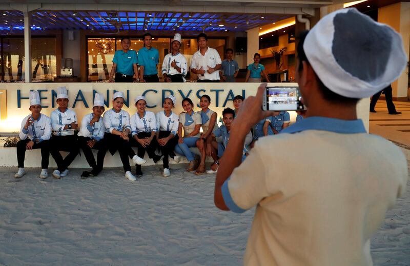 Hotel workers who are cut-off from their jobs pose for a picture, a day before the temporary closure of the holiday island Boracay. Erik De Castro / Reuters