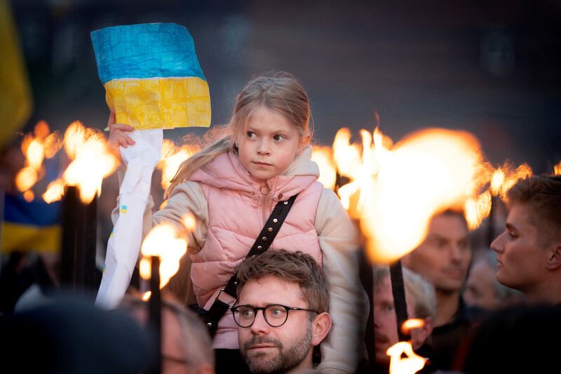 People wait for Ukrainian President Volodymyr Zelenskyy to begin a speech televised on a screen in City Hall Square in Copenhagen, Denmark. Reuters