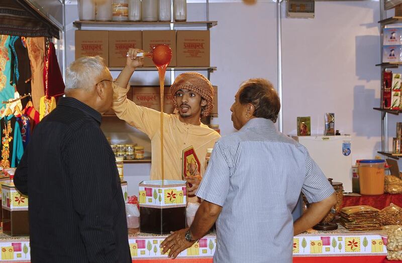 Saleh Fall Abdulla proudly demonstrates the purity of his honey at the Ramadan and Eid Fair at the Expo Centre Sharjah.  Jeffrey E Biteng / The National 