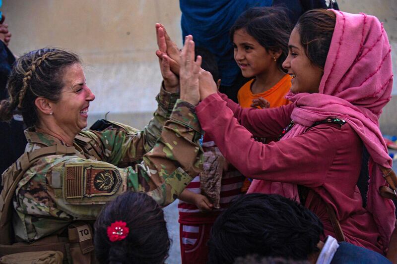 A US soldier with a reunited family at the airport in Kabul. AFP