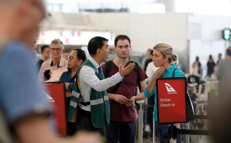 Passengers talk with a member of the airport staff after the announcement that all airport operations are suspended due to an anti-government demonstration at Hong Kong Airport. Reuters