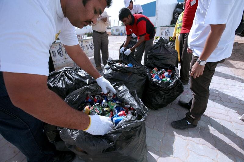 Environment-loving volunteers bag discarded aluminium drink cans in the Emirates Environmental Group’s can collection day. Fatima Al Marzooqi / The National