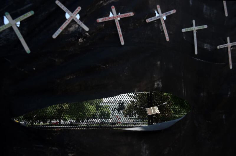 The White House is seen through the hole of a "Black Lives Matter" banner displaying crosses with the names of black victims who died of police brutality in Washington, DC.  AFP
