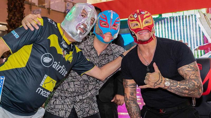 The masked wrestler poses with fans at the event.