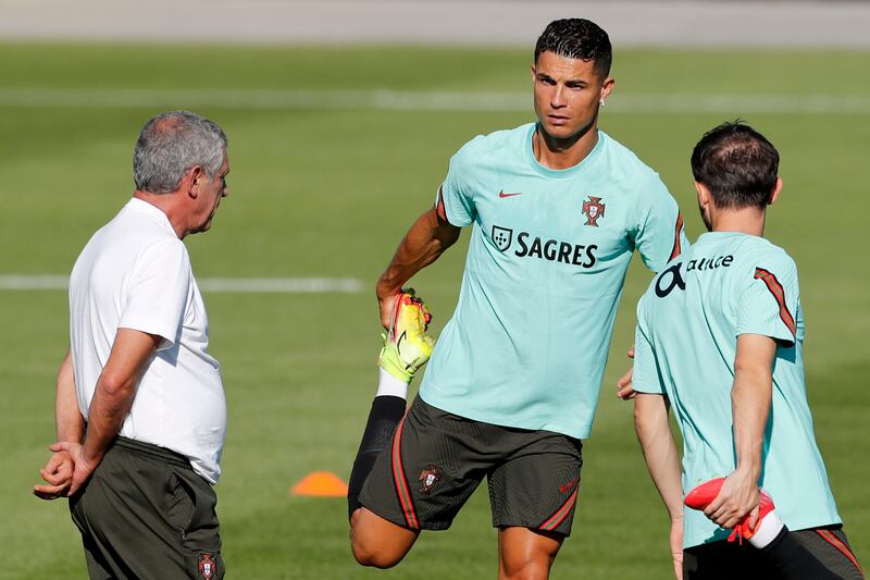 Portugal's Cristiano Ronaldo looks at coach Fernando Santos while stretching during a training session in Oeiras, outside Lisbon, Monday, Aug.  30, 2021.  Portugal will play Ireland on Wednesday in a Qatar 2022 World Cup qualifying match.  (AP Photo / Armando Franca)