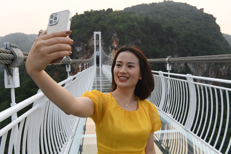 A visitor takes a selfie on the bridge. Authorities are hoping it will attract tourists after months of Covid-19 closures. 