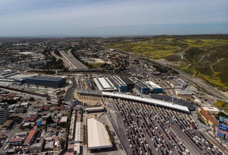 Aerial view of cars waiting to cross the San Ysidro Port of Entry bording crossing that connects the US-Mexico border cities of San Diejo and Tijuana seen from Tijuana, in Baja California state, Mexico, on March 29, 2019.  President Donald Trump on Friday again accused Mexico of failing to curb the flow of migrants illegally entering the US, and threatened to close the common border "next week" unless something changes. Trump's latest tweets ramp up the tension between the neighbors, putting a specific timeframe to his threats to shut the border, one of the busiest in the world. / AFP / Guillermo Arias
