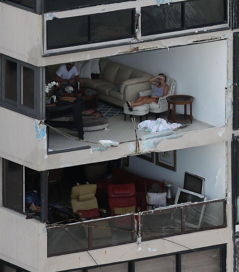 People sit in their apartment with the window blown out by the winds of Hurricane Maria in San Juan Puerto Rico. Joe Raedle / Getty Images