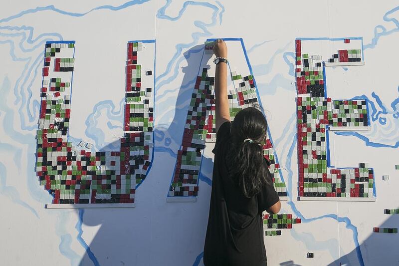 A resident helps construct a mosaic at the 45th National Day event on Yas Island Marina. Mona Al Marzooqi/ The National