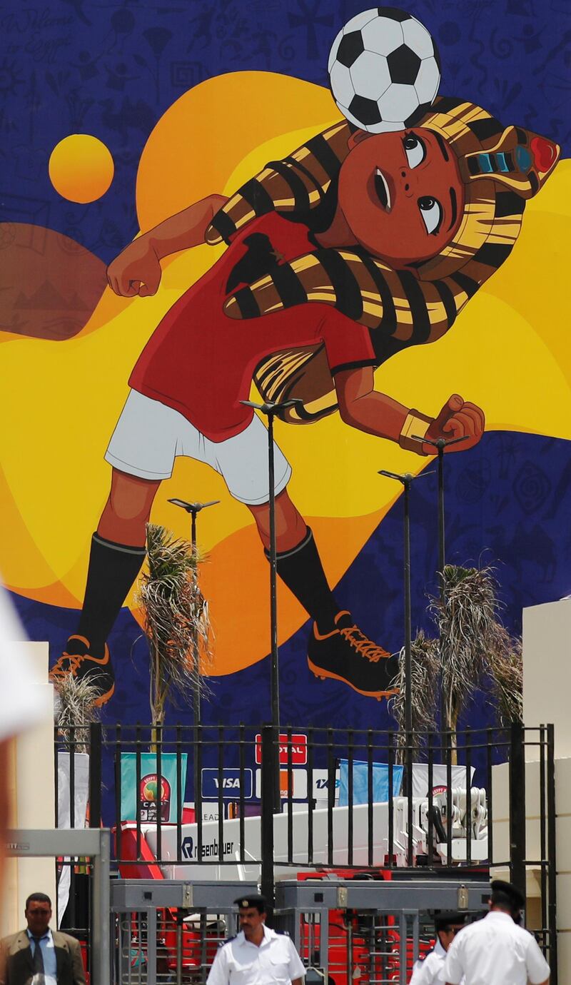 Police officers walk in front of a picture of Egyptian mascot for the Africa Cup of Nations, named "TUT" at the Cairo International Stadium ahead of the Africa Cup of Nations opening soccer match between Egypt and Zimbabwe in Cairo, Egypt.  Reuters