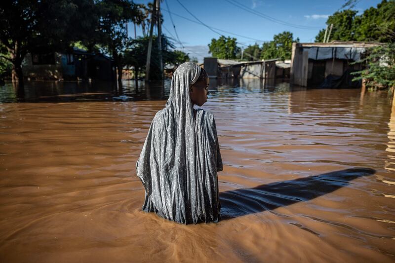 A woman wades through flood waters in a residential area of Garissa, eastern Kenya. The country is grappling with one of its worst floods in recent history. AFP