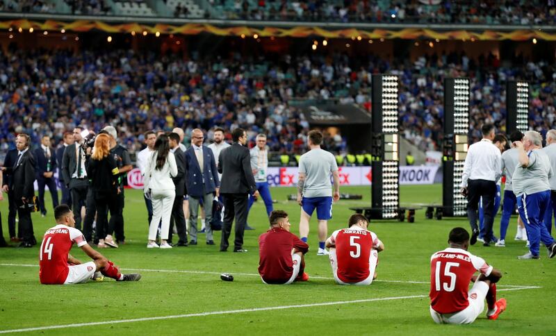 Arsenal's Pierre-Emerick Aubameyang, Sokratis Papastathopoulos and Ainsley Maitland-Niles look dejected. REUTERS