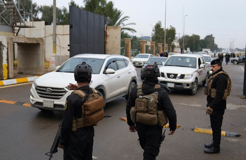 Iraqi security forces keep watch as motorists enter the Green Zone in Baghdad on Sunday. AP