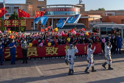 JIUQUAN, CHINA - JUNE 17: Chinese astronauts from China's Manned Space Agency, right to left, Nie Haisheng, Liu Boming, and Tang Hongbo wave at a departure ceremony before the launch of the Senzhou-12 at the Jiuquan Satellite Launch Center on June 17, 2021 in Jiuquan, Gansu province, China. The crew of the Shenzhou-12 spacecraft will be carried on the Long March-2F rocket launched to the space station China is building from the Gobi Desert marking the country's first manned mission in nearly five years. (Photo by Kevin Frayer/Getty Images)