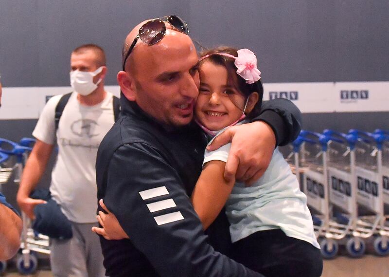 A daughter hugs her father at Skopje International Airport in North Macedonia, after he was repatriated from Afghanistan. EPA