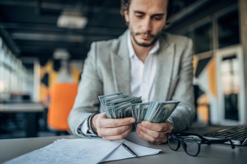 Handsome businessman working in the office and counting money