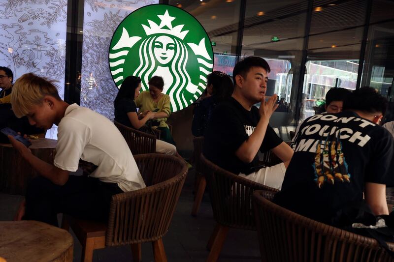 Chinese customers enjoy their drinks at a store of U.S. coffee giant Starbucks in Beijing on Friday, May 10, 2019. U.S. President Donald Trump's latest tariff hike on Chinese goods took effect Friday and Beijing said it would retaliate, escalating a battle over China's technology ambitions and other trade tensions. (AP Photo/Ng Han Guan)