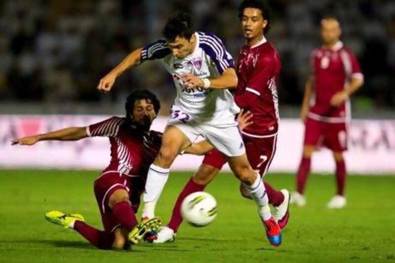 Al Wahda’s Yaqoub Yousef tackles Al Ain’s Ignacio Scocco at the Tahnoun bin Mohammed Stadium last night.