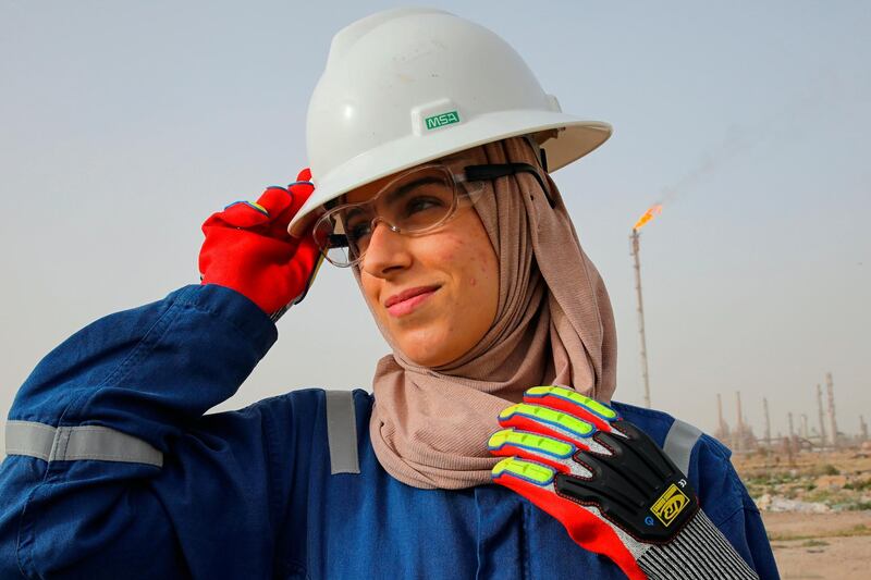 Zainab Amjad, a petrochemical engineer, poses for a photo near an oil field outside Basra, Iraq, Monday, Feb. 18, 2021. Amjad is among just a handful of women who have eschewed the dreary office jobs typically handed to female petrochemical engineers in Iraq. Instead, they chose to become trailblazers in the country's oil industry, taking up the grueling work of drilling. (AP Photo/Nabil al-Jourani)
