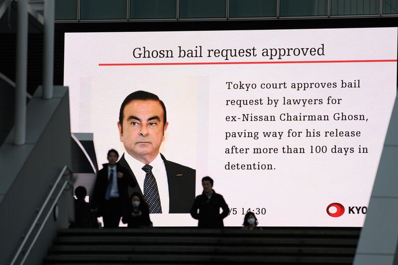 Pedestrians walk past a screen displaying a news broadcast on former Nissan Motor Co. Chairman Carlos Ghosn in Tokyo, Japan, on Tuesday, March 5, 2019. Ghosn’s impending release from a Tokyo jail is in jeopardy after prosecutors appealed a decision granting bail to the fallen car titan after 107 days in custody. Photographer: Akio Kon/Bloomberg