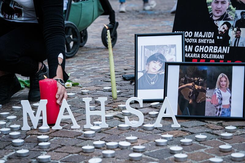 A person places a candle during the demonstration in Turin. EPA