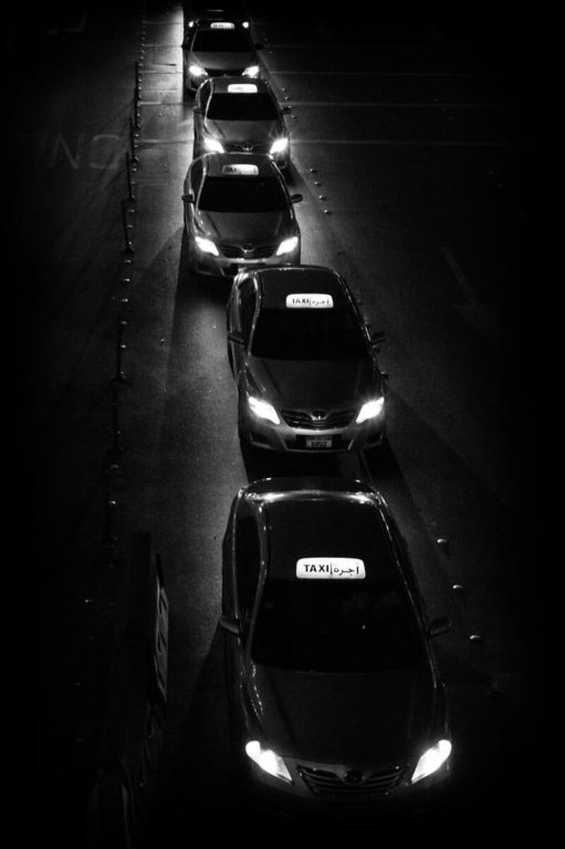 Taxis overflow from the taxi stand into the street in front of Abu Dhabi Mall, while waiting for customers. Brian Kerrigan / The National