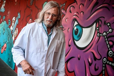 French medecine professor Didier Raoult walks along a wall painted by graffitti artist Jace at his IHU medical institute in Marseille on June 3, 2020, where his work have been at the forefront of promoting hydroxychloroquine as a potential treatment for COVID-19 and has also been subject to criticisms over methodology as the World Health Organization (WHO) now suspended clinical trials of the anti-viral drugs after The Lancet  published an "expression of concern" over a large-scale study of hydroxychloroquine and chloroquine. / AFP / Christophe SIMON
