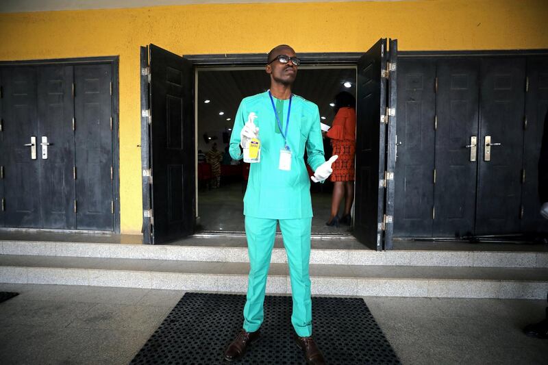 A man stands prepared with sanitiser at the entrance of a Living Faith Church, following the outbreak of coronavirus in Abuja, Nigeria. Reuters