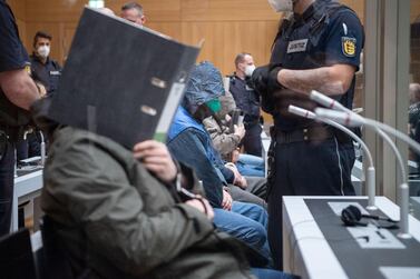 A defendant covers his face at the beginning of the trial in Stuttgart. Reuters