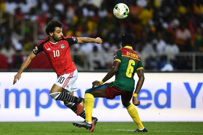 Egypt forward Mohamed Salah, left, vies for the ball against Cameroon defender Ambroise Oyongo. Gabriel Bouys / AFP